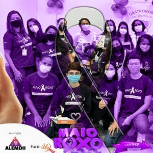 O slide com película lilás traz a foto de um grupo de pacientes com Doença Inflamatória Intestinal. Todos jovens, homens e mulheres, usando máscara e com a camiseta MAIO ROXO. É possível, apesar das máscaras, ver que todos sorriem! No rodapé a palavra “realização” seguida do logotipo da ALEMDII e da Farmale. No centro o sticker MAIO ROXO.